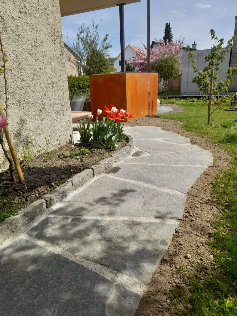 Verlegung von Bodenplatten. Gestaltung Hochbeet aus Eisen.